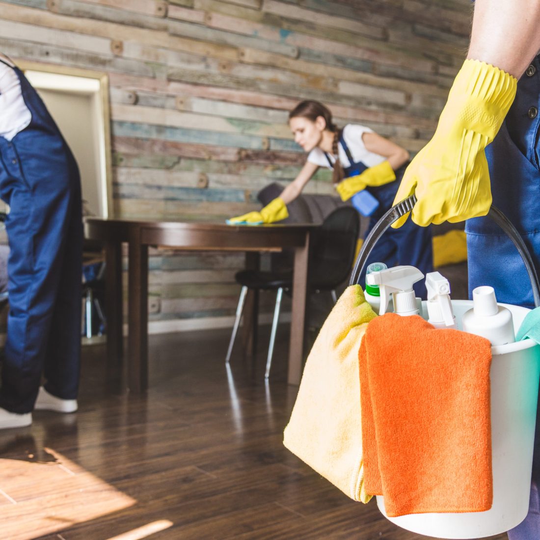 Cleaning service with professional equipment during work. professional kitchenette cleaning, sofa dry cleaning, window and floor washing. man and women in uniform, overalls and rubber gloves.